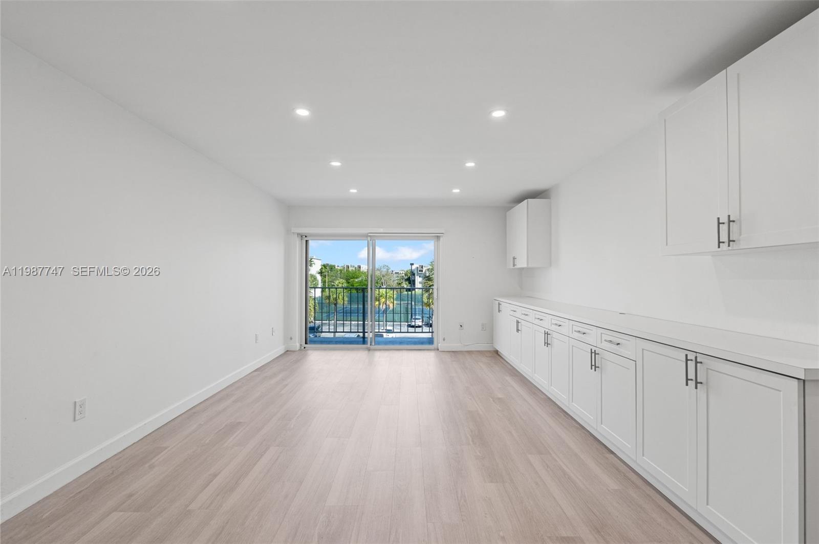 7765 Southwest 86th Street, Unit F2303 Miami, FL 33143 - Photo 4 of 50 a view of an empty room with wooden floor and windows