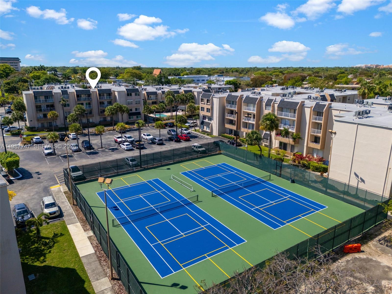 7765 Southwest 86th Street, Unit F2303 Miami, FL 33143 - Photo 42 of 50 a view of a tennis ground with lawn chairs