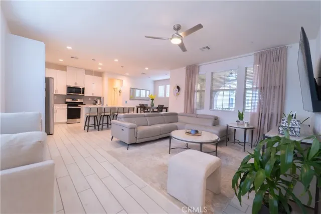 a living room with furniture kitchen view and a chandelier