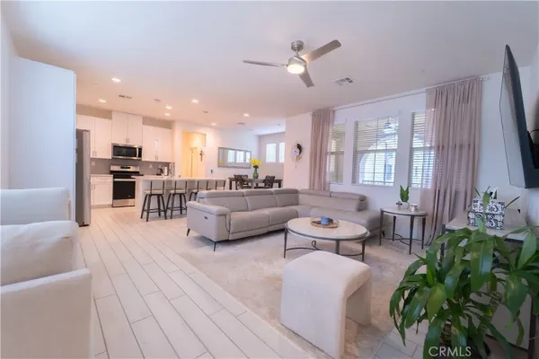 a living room with furniture kitchen view and a chandelier