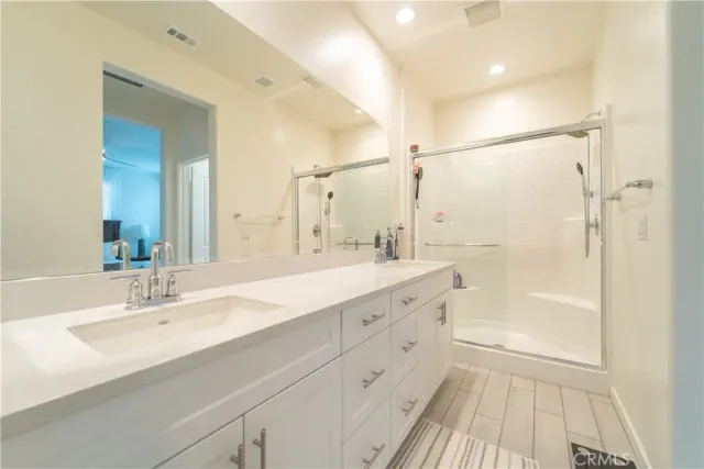 a bathroom with a double vanity sink mirror double and shower