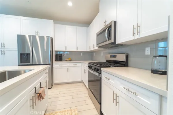 a kitchen with stainless steel appliances granite countertop a refrigerator sink and cabinets