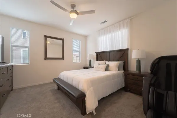 a large bed sitting in a bedroom next to a window and a chandelier