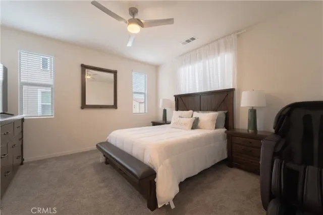 a large bed sitting in a bedroom next to a window and a chandelier