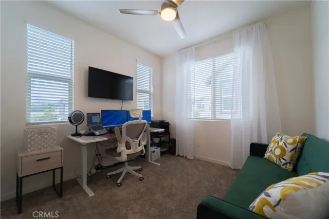 a view of a livingroom with workspace and a window