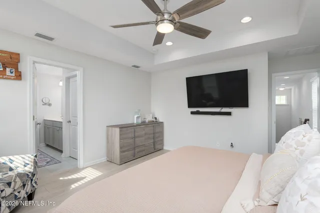 a bedroom with a large bed and a chandelier