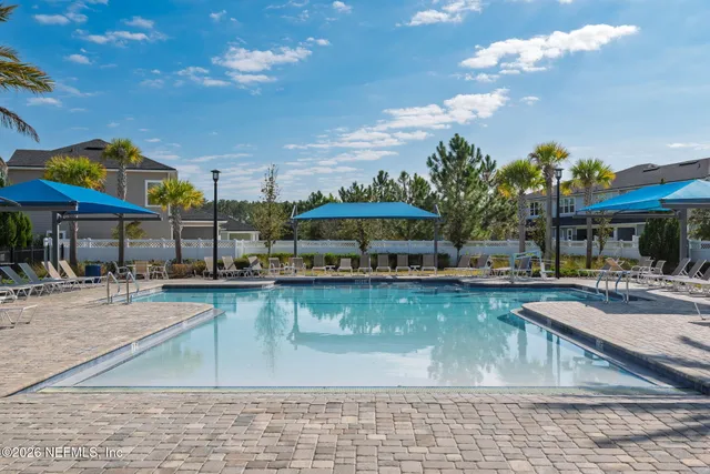 a house view with swimming pool in front of it