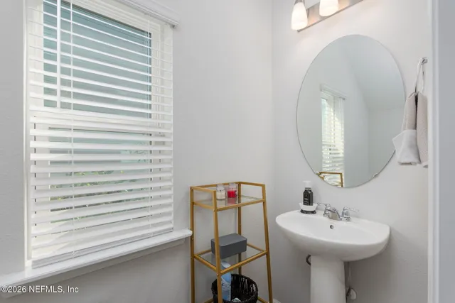 a bathroom with a sink a mirror and a window