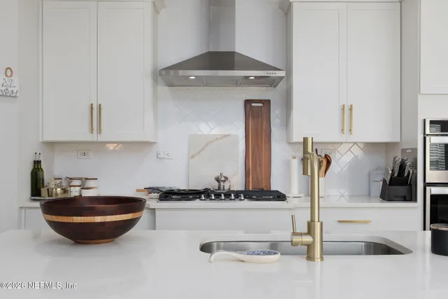 a open kitchen with stainless steel appliances granite countertop a sink a stove and a wooden floors