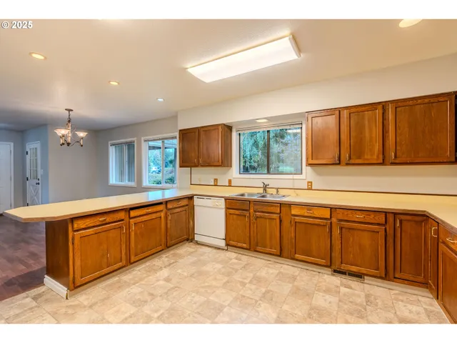 a large kitchen with stainless steel appliances granite countertop a sink and cabinets
