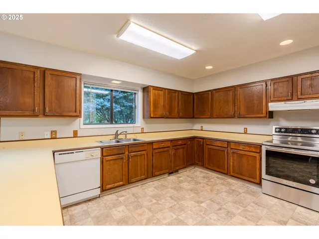 a kitchen with stainless steel appliances granite countertop a stove sink and cabinets