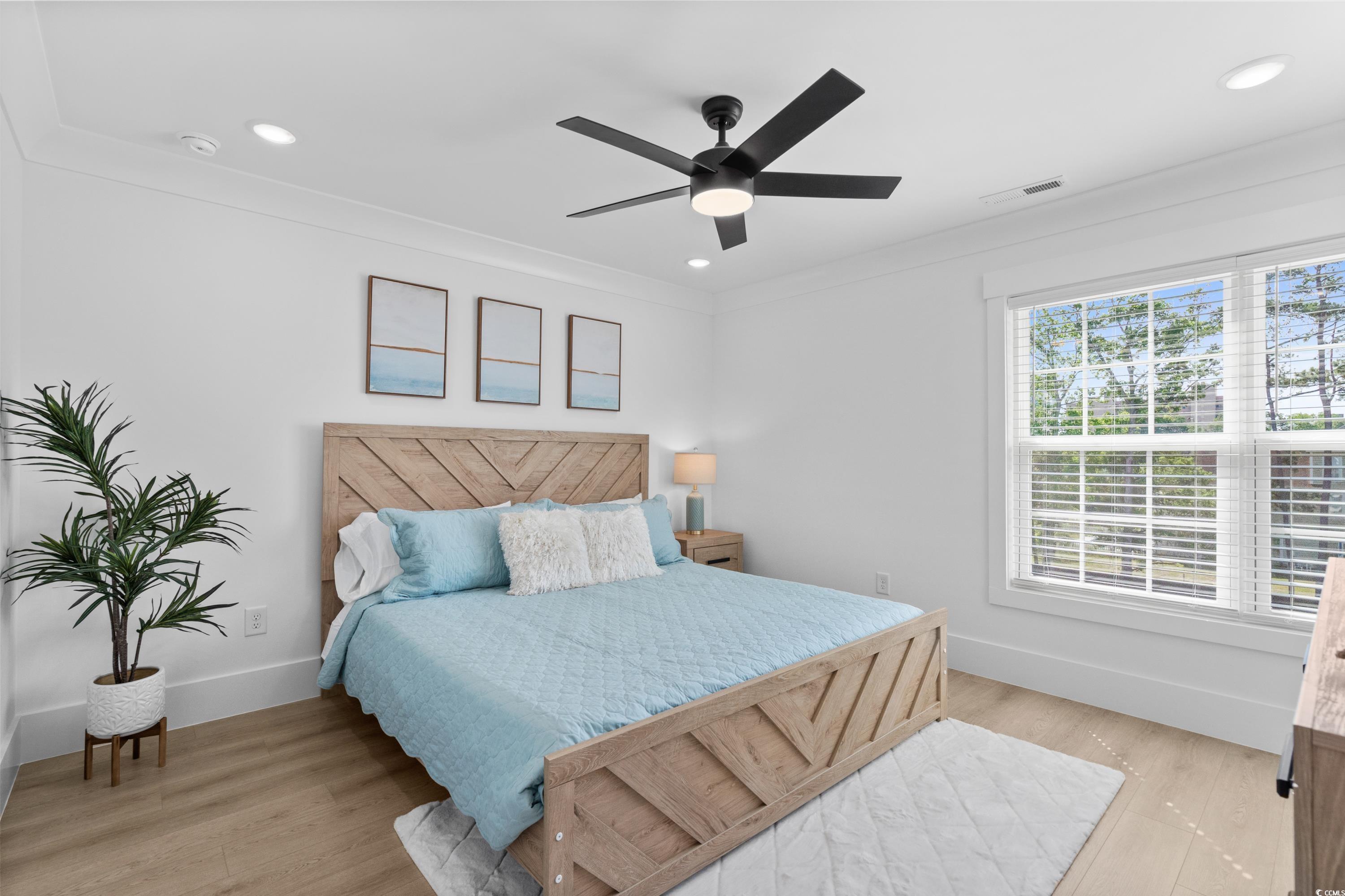 2303 Seaseeker Lane Myrtle Beach, SC 29577 - Photo 33 of 38 Bedroom with multiple windows, light wood finished floors, and baseboards