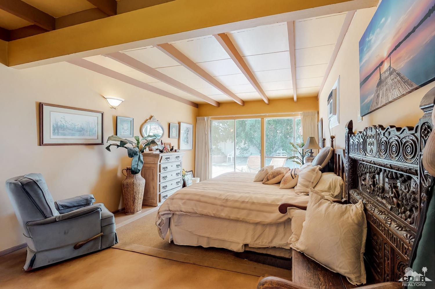 71906 Vista Del Rio Rancho Mirage, CA 92270 - Photo 20 of 27 a bedroom with furniture and a large window