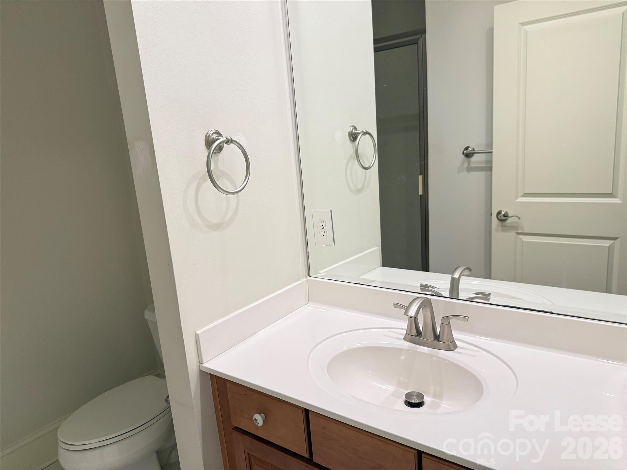 421 Spring Street Davidson, NC 28036 - Photo 19 of 24 a bathroom with a granite countertop toilet sink and mirror