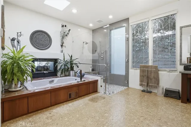 a bedroom with a large bed and windows