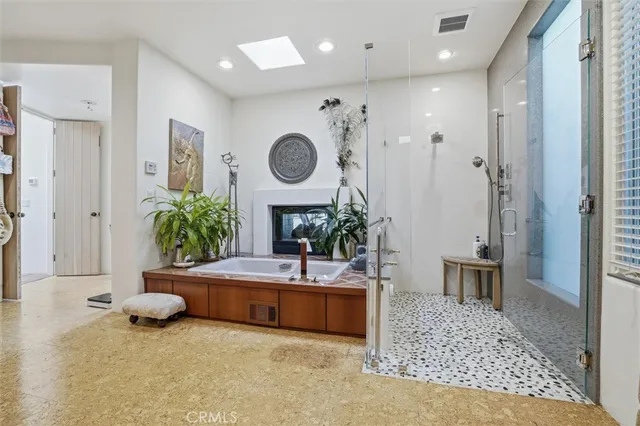 a bedroom with a bed and a large window with the potted plants