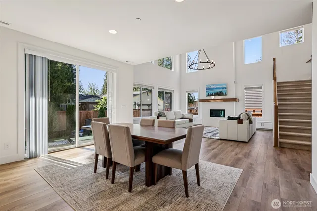 a kitchen with stainless steel appliances granite countertop a refrigerator a sink dishwasher a stove and white cabinets with wooden floor