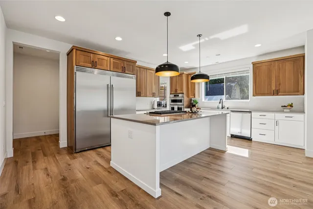 a kitchen with stainless steel appliances granite countertop a sink and a refrigerator