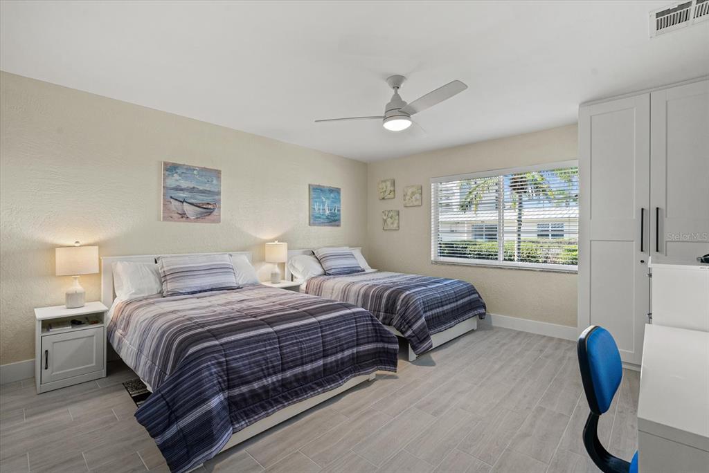 5830 Midnight Pass Road, Unit 63 Sarasota, FL 34242 - Photo 12 of 27 a bedroom with a bed and a chair