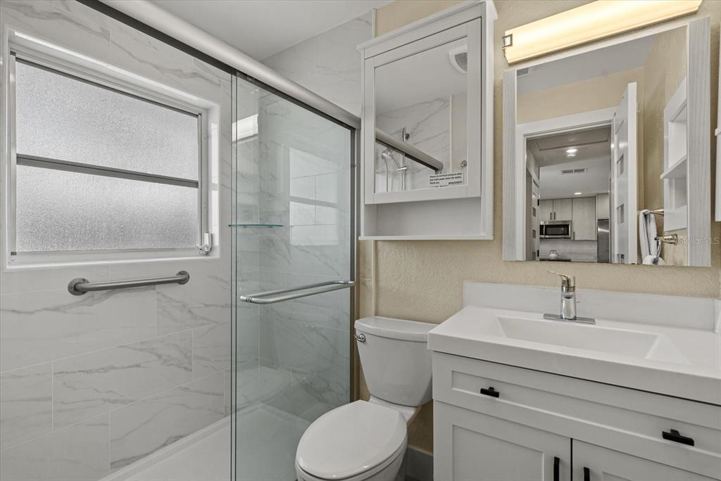 5830 Midnight Pass Road, Unit 63 Sarasota, FL 34242 - Photo 15 of 27 a bathroom with a sink toilet and shower