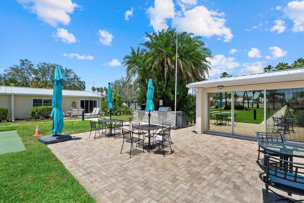 5830 Midnight Pass Road, Unit 63 Sarasota, FL 34242 - Photo 21 of 27 a view of a house with backyard sitting area and garden