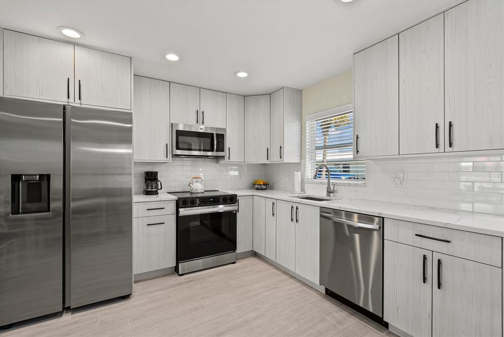 5830 Midnight Pass Road, Unit 63 Sarasota, FL 34242 - Photo 3 of 27 a kitchen with cabinets stainless steel appliances and a counter top space