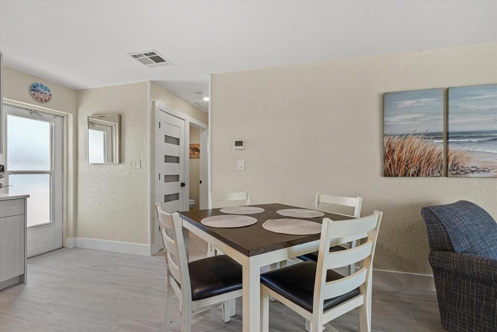 5830 Midnight Pass Road, Unit 63 Sarasota, FL 34242 - Photo 6 of 27 a view of a dining room with furniture and wooden floor