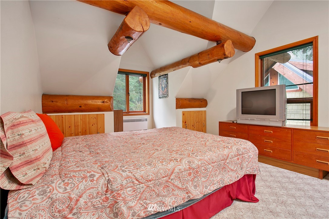 7097 Rainier Way Deming, WA 98244 - Photo 16 of 37 a bedroom with a large bed and a flat screen tv