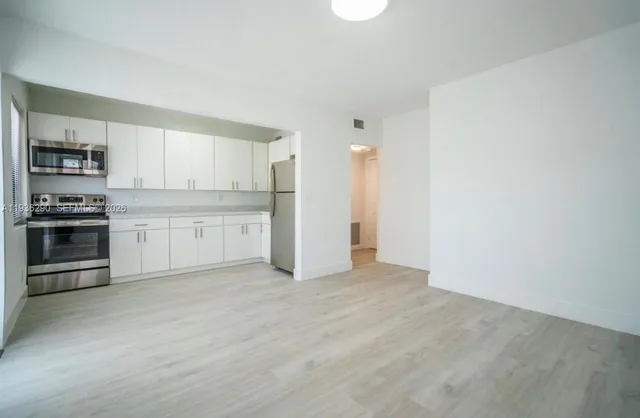 a view of kitchen with wooden floor and electronic appliances