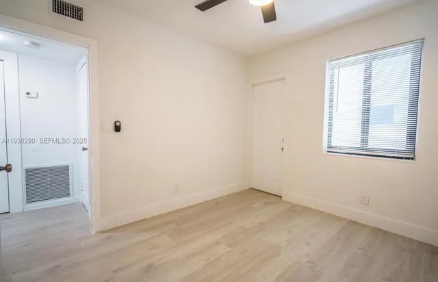 an empty room with windows and closet