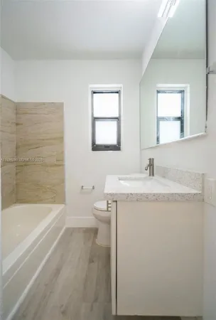 a bathroom with a granite countertop sink toilet and bathtub
