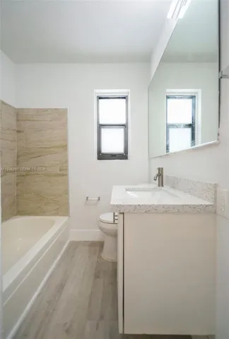 a bathroom with a granite countertop sink toilet and bathtub