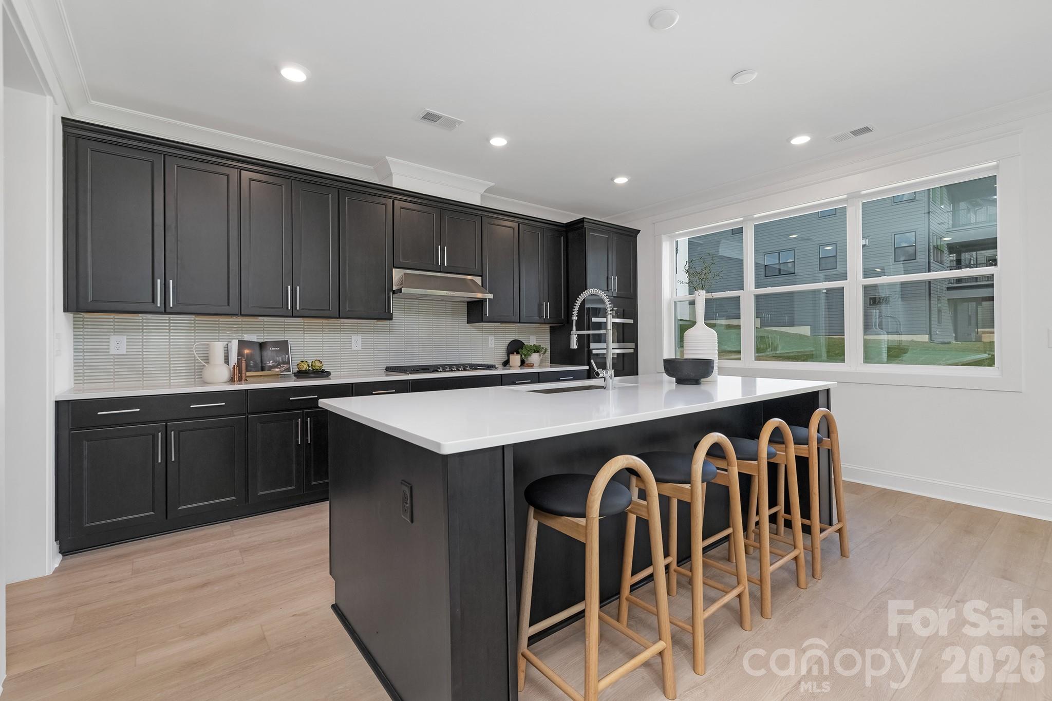 220 Windy Dell Drive Tega Cay, SC 29708 - Photo 4 of 13 a kitchen with kitchen island granite countertop a stove top oven a sink a counter space and cabinets