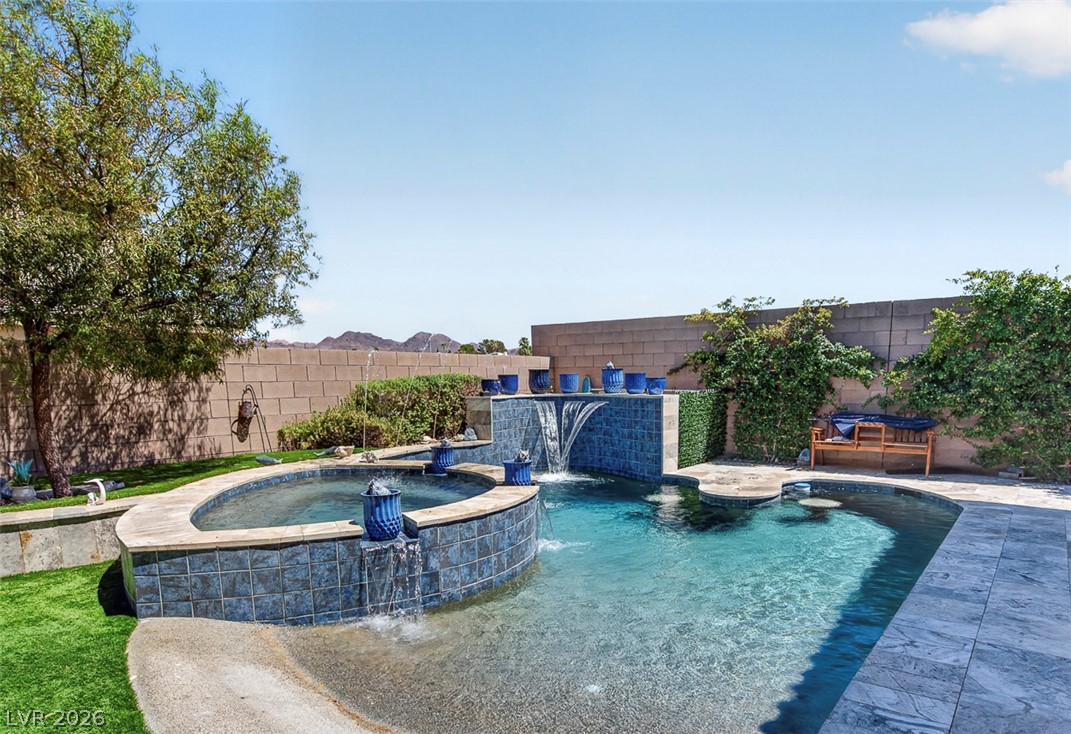 1824 Redland Ridge Street Henderson, NV 89002 - Photo 57 of 69 An inviting backyard oasis offers a sparkling pool with a tranquil waterfall and a separate spa.