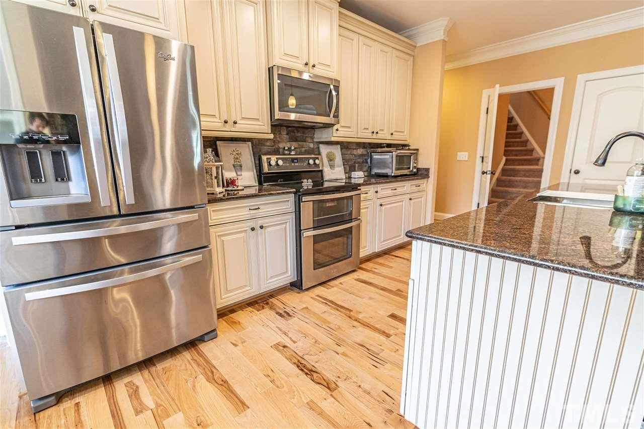 535 Barber Road Carthage, NC 28327 - Photo 11 of 30 a kitchen with stainless steel appliances granite countertop a refrigerator a stove and a sink with wooden floor