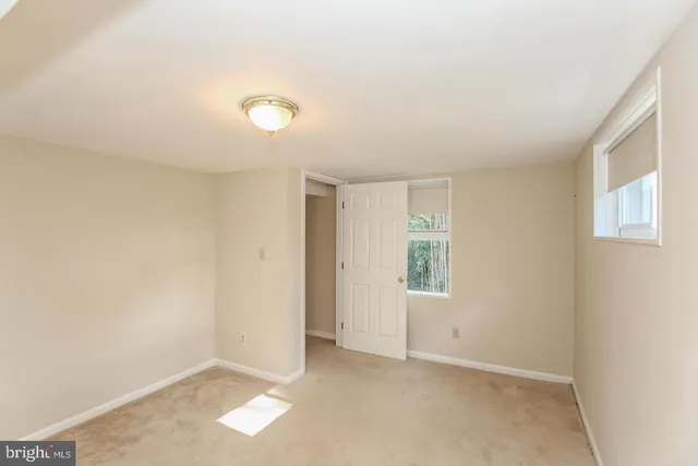 an empty room with windows and closet