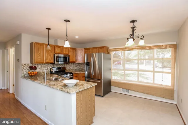 a kitchen with sink refrigerator and microwave
