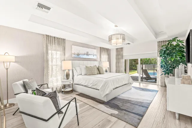 a spacious bedroom with a large bed and a chandelier