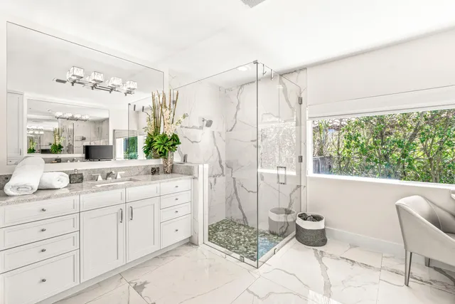 a spacious bathroom with a granite countertop sink and a mirror