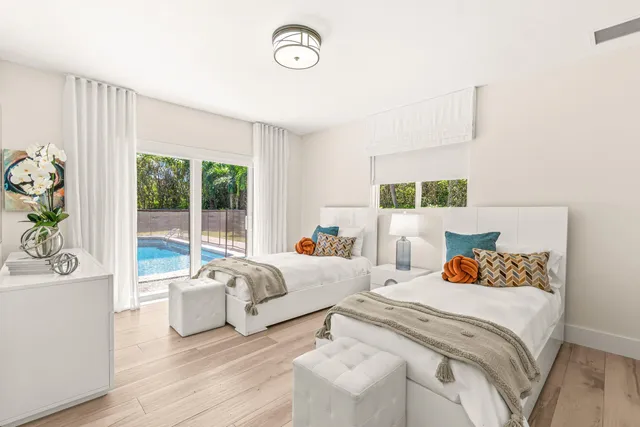 a bedroom with two beds and a large window