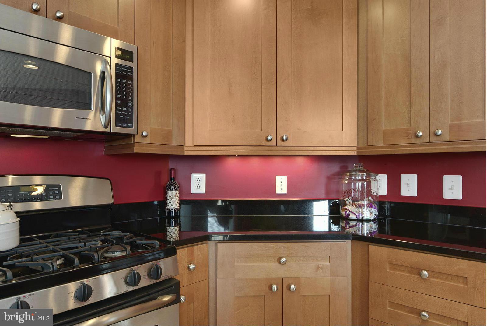 11990 Market Street, Unit 801 Reston, VA 20190 - Photo 9 of 25 a kitchen with granite countertop a stove and cabinets