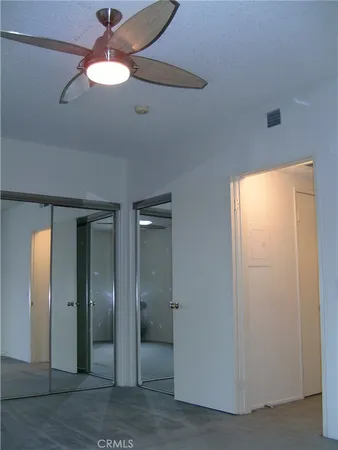 an empty room with windows and closet