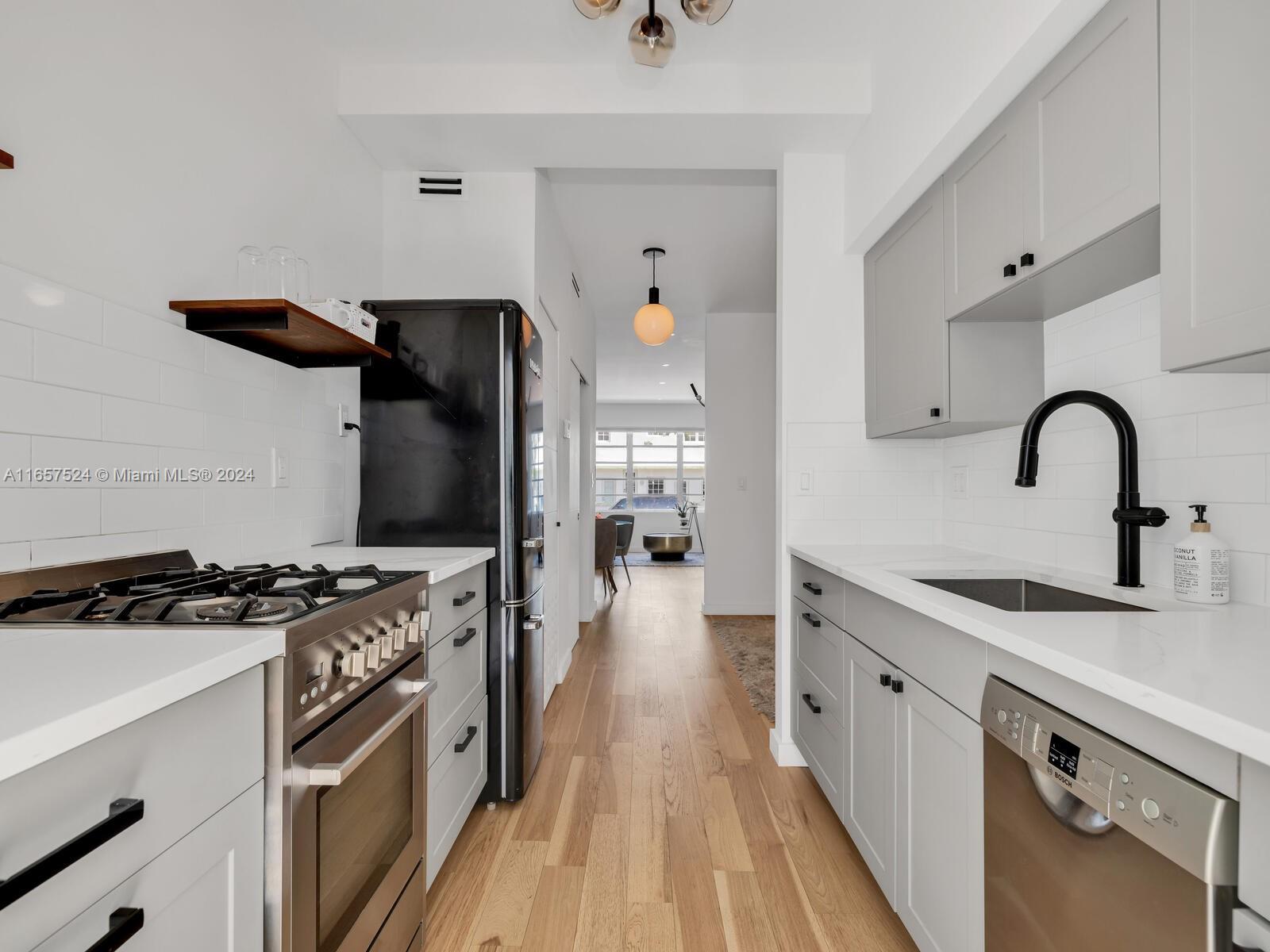 742 12th Street, Unit 2 Miami Beach, FL 33139 - Photo 1 of 27 a kitchen with granite countertop a stove and a sink