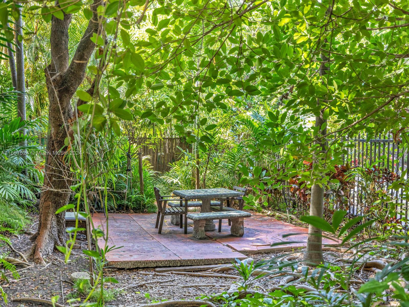 742 12th Street, Unit 2 Miami Beach, FL 33139 - Photo 23 of 27 a wooden bench sitting in the middle of a garden