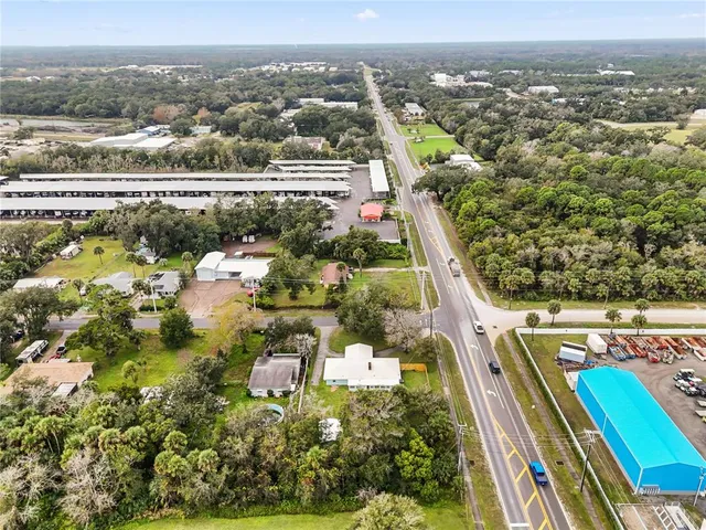 an aerial view of a residential houses with yard