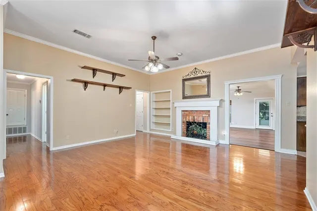 a view of a livingroom with wooden floor a fireplace and window