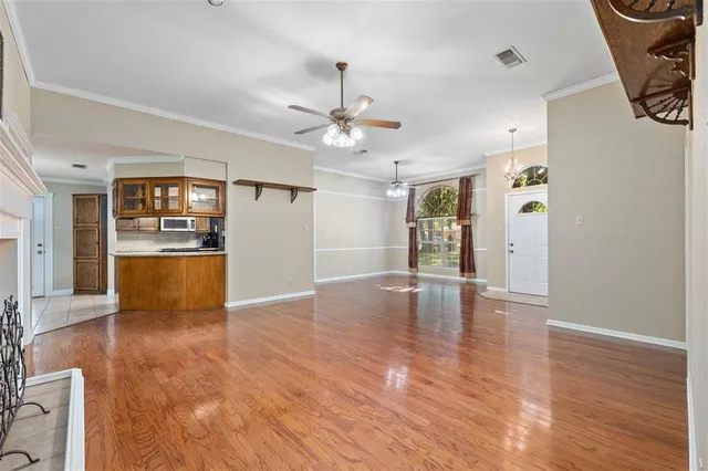 a view of an empty room with window and wooden floor