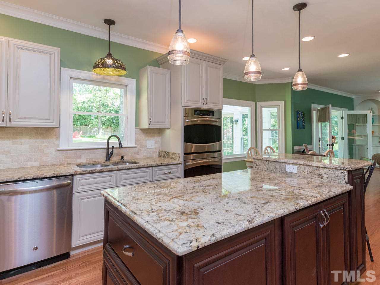 1401 October Road Raleigh, NC 27614 - Photo 8 of 30 a kitchen with a center island wooden floor cabinets and window