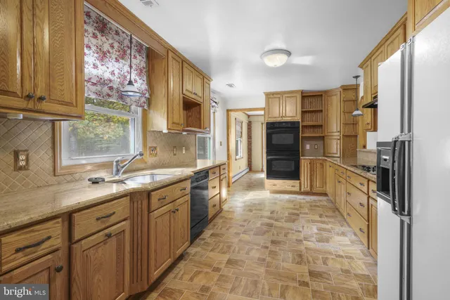 a kitchen with granite countertop a sink and a refrigerator