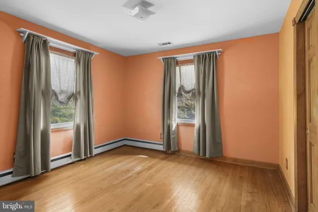 a bedroom with a bed and a dresser next to a window